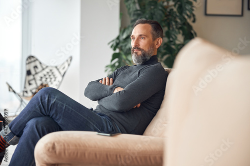 Happy adult caucasian man is sitting in a lounge zone and chilling
