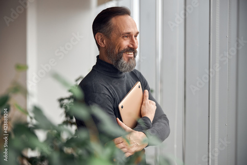 Happy adult caucasian man is working in a modern office