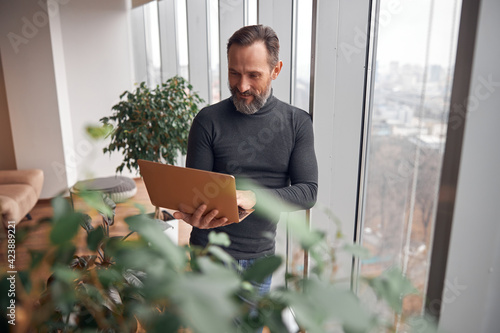 Happy adult caucasian man is working in a modern office