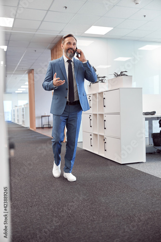 Happy adult caucasian man is working in a modern office