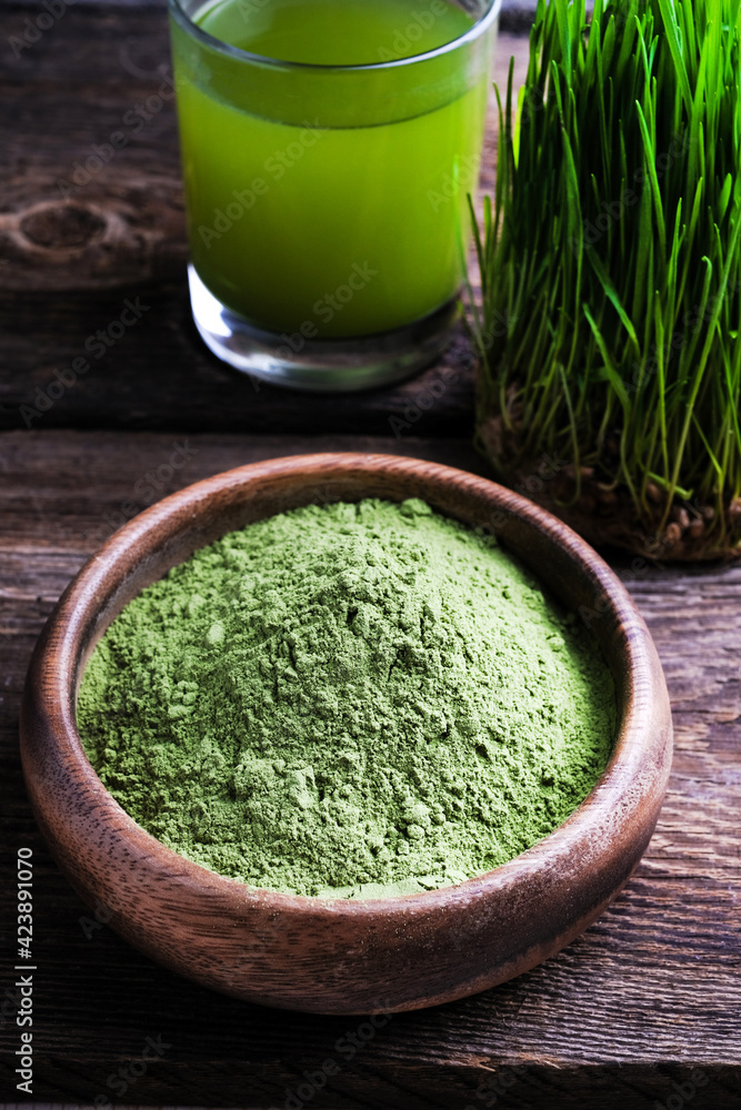 Detox Green Barley Sprout grass, bowl and a spoon with Powder . Space for Text on wooden background Detox Green Barley Sprout grass, bowl and a spoon with Powder . Space for Text on wooden background