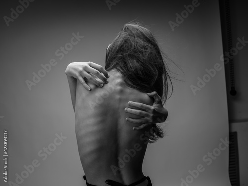 Woman black and white photography portrait rear view touching back with hands