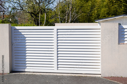 steel white slide gate aluminum portal with blades of suburban house
