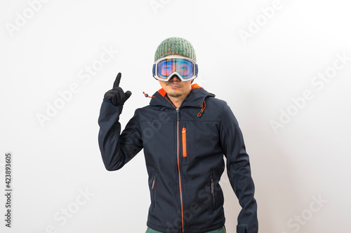 Asian man in winter coat, goggles and glove dressing for snowboarder on white background.