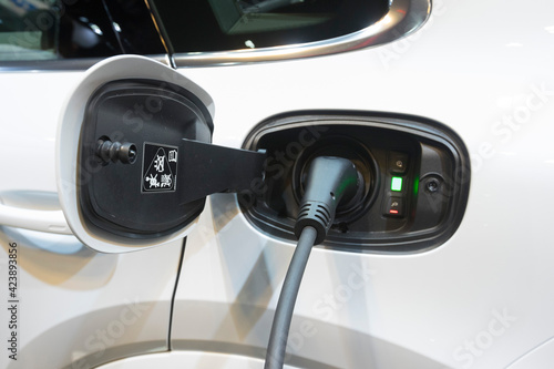 Close up view of vehicle electric charging socket plug in to recharge in Bangkok, Thailand.