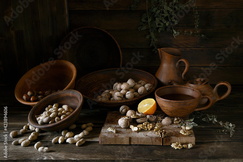 Nuts in an earthenware dish on a wooden table.