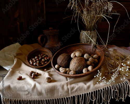 Nuts in an earthenware dish on a wooden table.