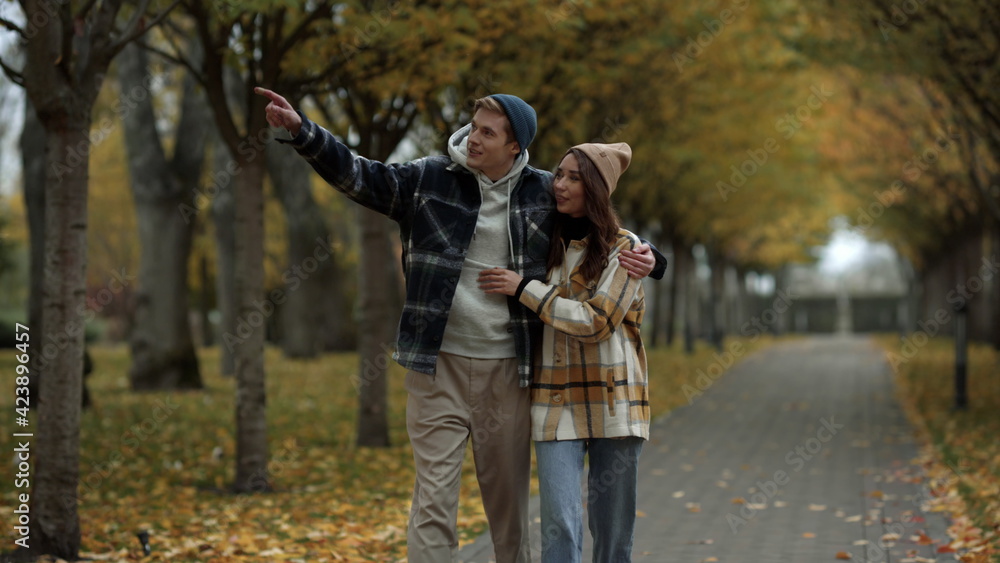 Beautiful young couple in love walking in fall park. Smiling handsome boy . Beautiful young couple in love walking in fall park. Smiling handsome boy .