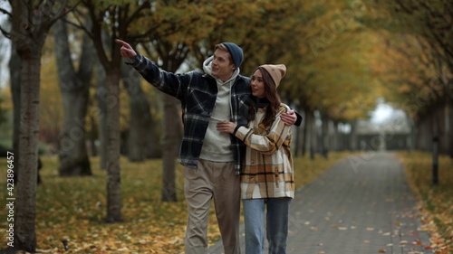 Beautiful young couple in love walking in fall park. Smiling handsome boy . © stockbusters