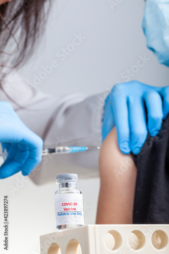 Clinical trials are ongoing for the safety and efficacy of COVID 19 vaccinations among children. A concept image showing a child getting COVID vaccine through intramuscular injection.