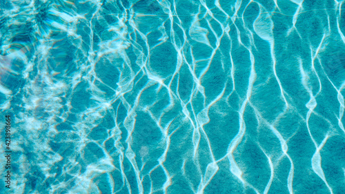 Abstract pool water.  Swimming pool bottom caustics ripple and flow with waves background surface of blue swimming pool