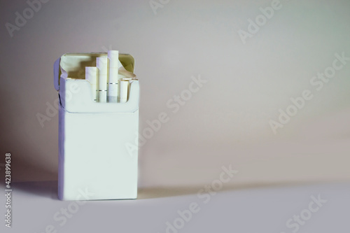 A pack of cigarettes on a light gray background. Loneliness.