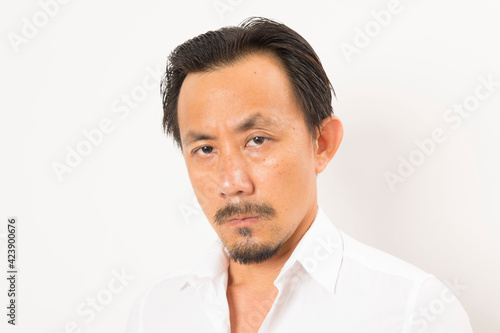 Head shot of middle aged Asian man looking at camera on white background.