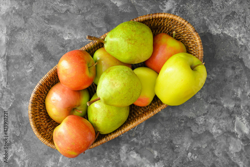 Fototapeta Naklejka Na Ścianę i Meble -  Basket with tasty apple and pear fruits on dark background