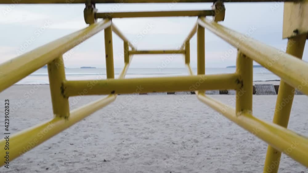 The moving yellow seesaw on the playground near the beach shore line The moving yellow seesaw on the playground near the beach shore line