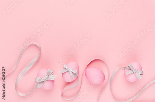 Fashion easter background - pink eggs with grey ribbon quaint stripes as border on pastel pink color.