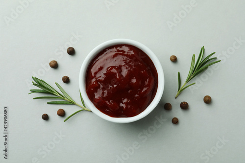 Bowl of barbecue sauce and spices on light gray background photo
