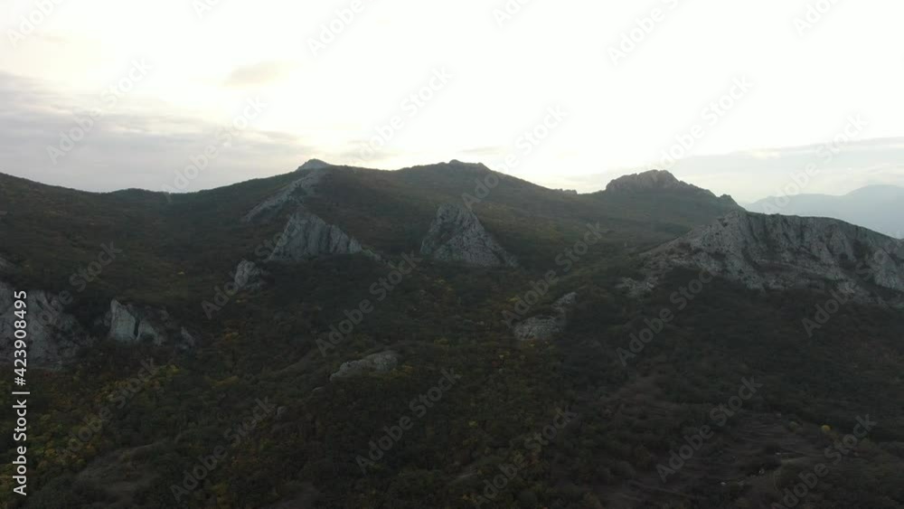 Aerial view of a forested ancient mountain. In some places, huge rocky ledges are visible. Autumn. Aerial view of a forested ancient mountain. In some places, huge rocky ledges are visible. Autumn.