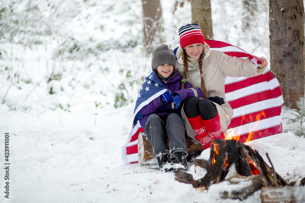 Happy family with american flag in winter scenery