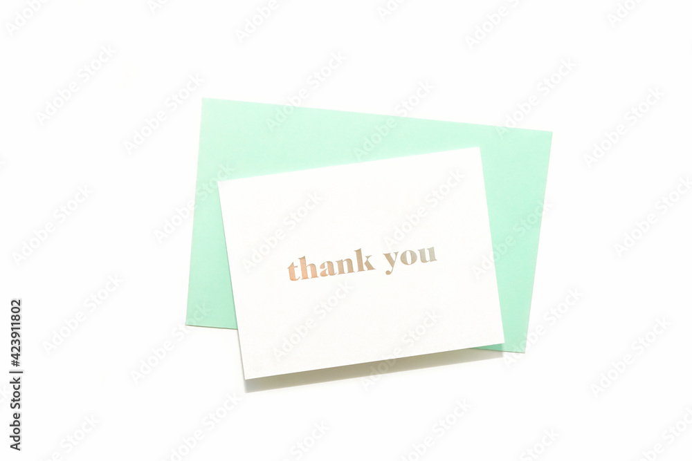 Thank you card on pastel green envelope on white background. Simple