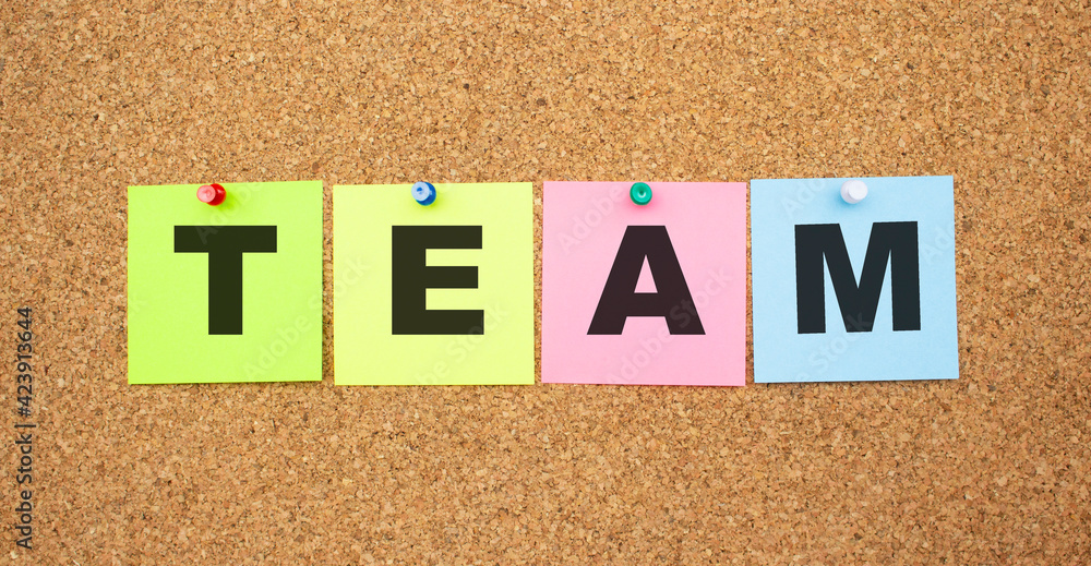 Color notes with letters pinned on a board. Word TEAM. Color notes with letters pinned on a board. Word TEAM.