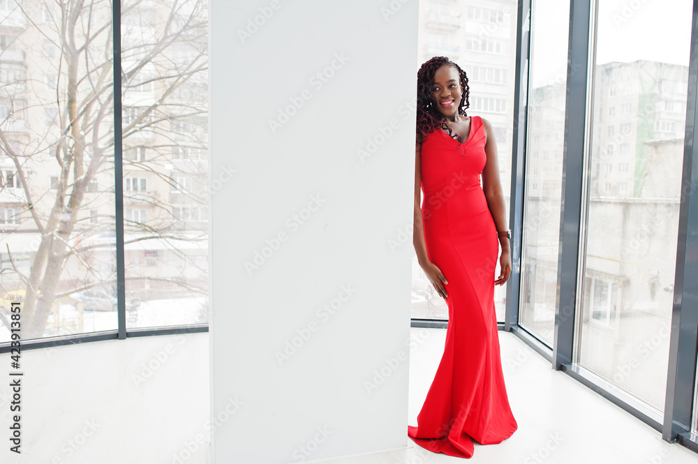 Magnificent young african woman in luxurious red dress in a luxury apartment. Beauty, fashion.