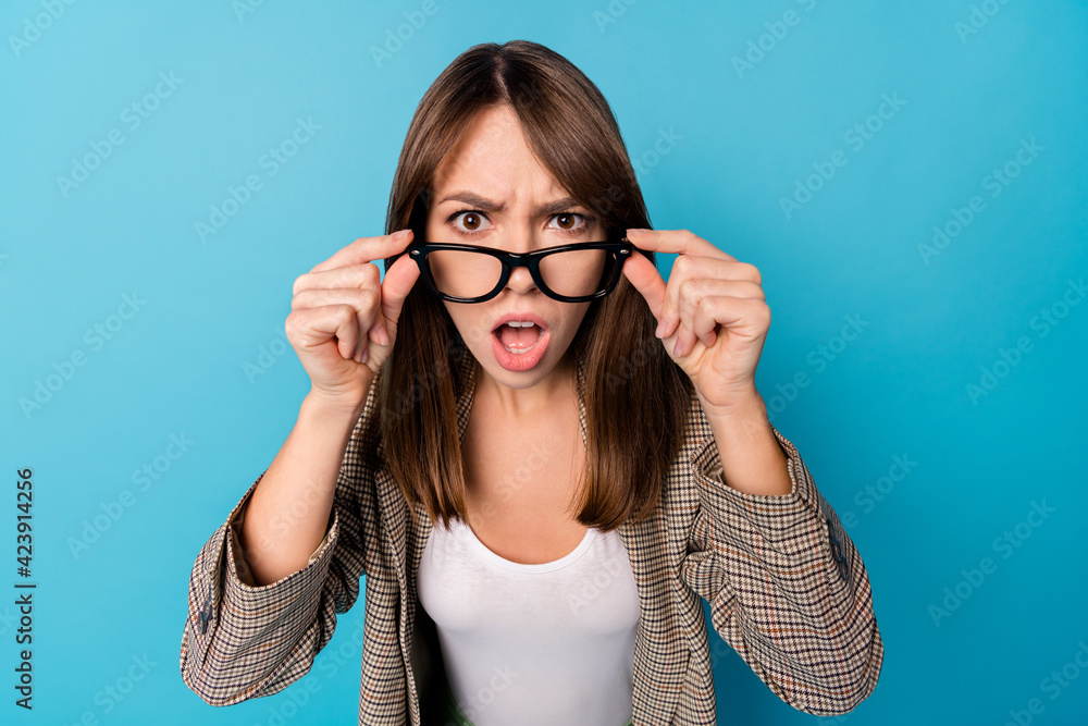 Photo of impressed nice brunette lady wear spectacles brown jacket isolated on vivid blue background Photo of impressed nice brunette lady wear spectacles brown jacket isolated on vivid blue background