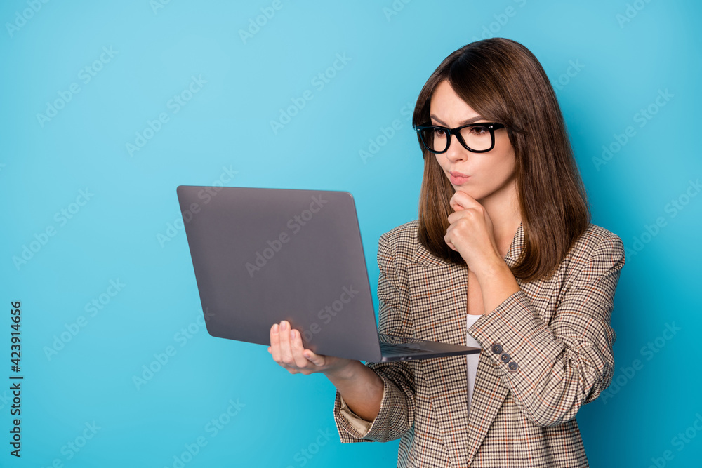 Portrait of brunette serious lady hold laptop wear spectacles brown blazer isolated on bright blue color background Portrait of brunette serious lady hold laptop wear spectacles brown blazer isolated on bright blue color background