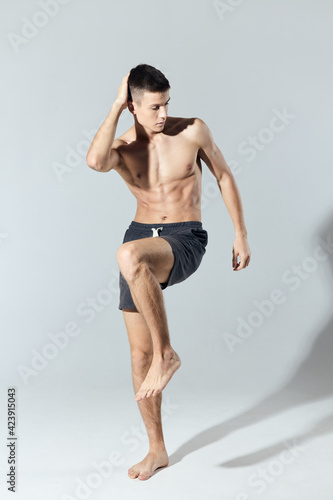 sportsman in shorts doing full length exercise indoors