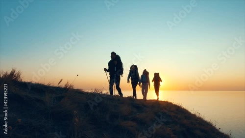 The four travelers walking on the mountain top near the sea. slow motion