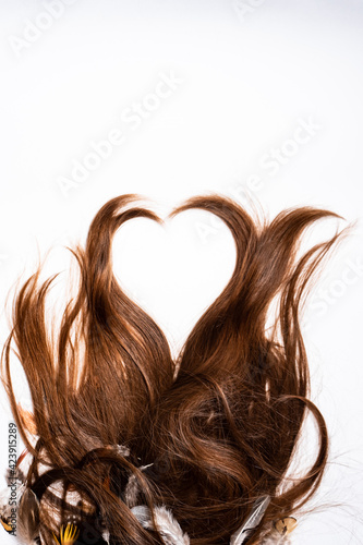 Hair lies in the shape of a heart on a white background