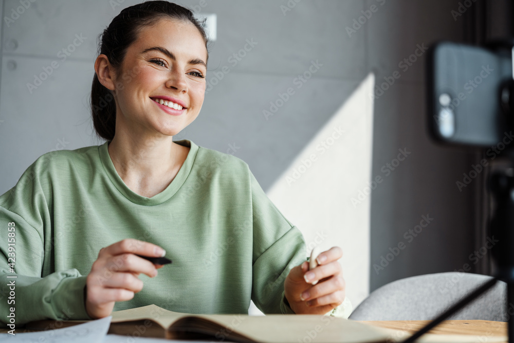 Smiling young brunette woman student studying online Smiling young brunette woman student studying online