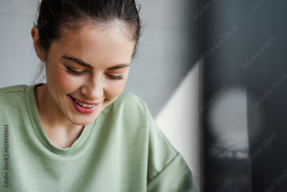Close up of a young brunette woman laughing looking down Close up of a young brunette woman laughing looking down
