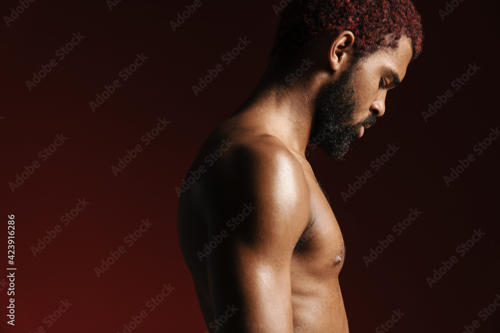 Fototapeta premium Black shirtless bearded man posing and looking downward