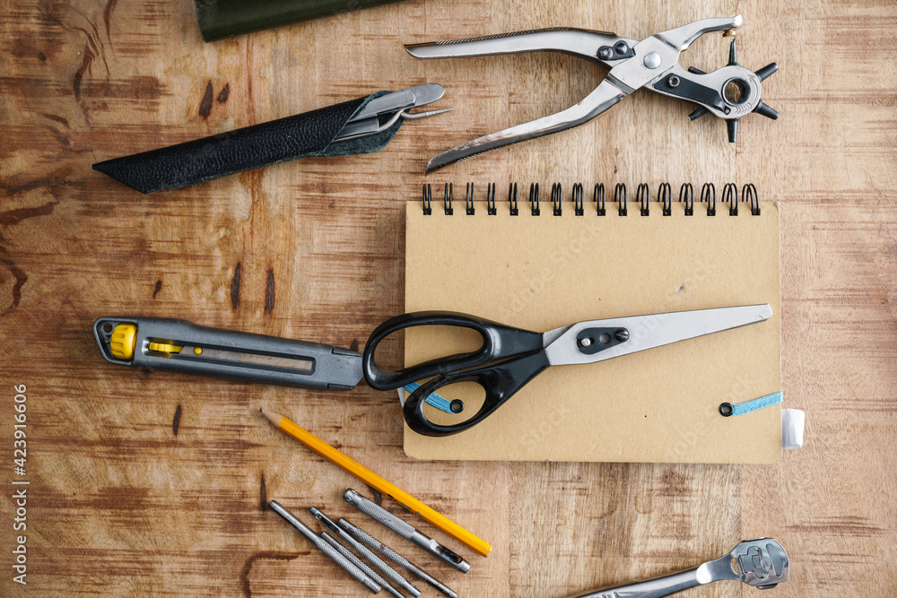 Tools and notebook lying on wooden table indoors Tools and notebook lying on wooden table indoors