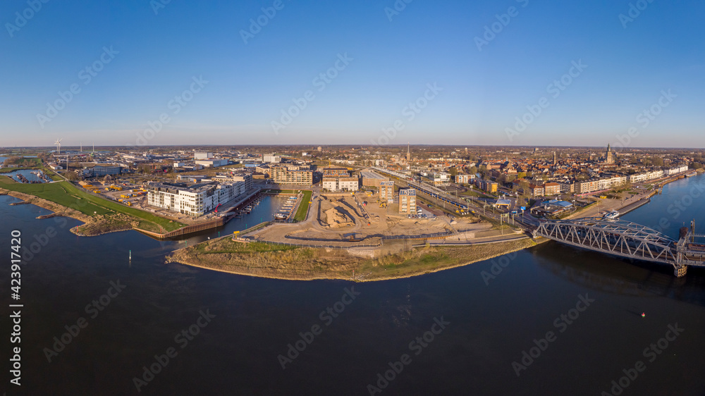 Aerial panoramic view on Kade Zuid construction site of the new Noorderhaven neighbourhood left and river IJssel that flows passed Hanseatic Dutch city of Zutphen,  The Netherlands, on the right
