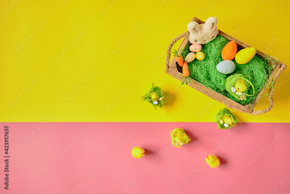 Obraz premium Easter eggs on the yellow -pink background. Happy Easter. Holiday concept. Focus on chicken on yellow background.