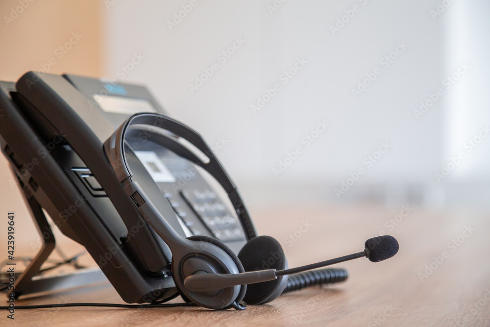 Communication support, call center and customer service help desk. VOIP headset on telephone keyboard. Communication support, call center and customer service help desk. VOIP headset on telephone keyboard.