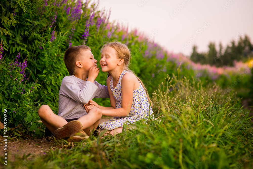 Fototapeta premium happy children in light clothes on the path in the park, a summer concept and a happy free childhood