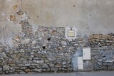 A single letterbox build in an old wall of bricks and a power supply 