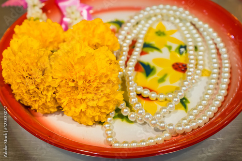 A row of marigold flower garlands which are used traditionally in thailand