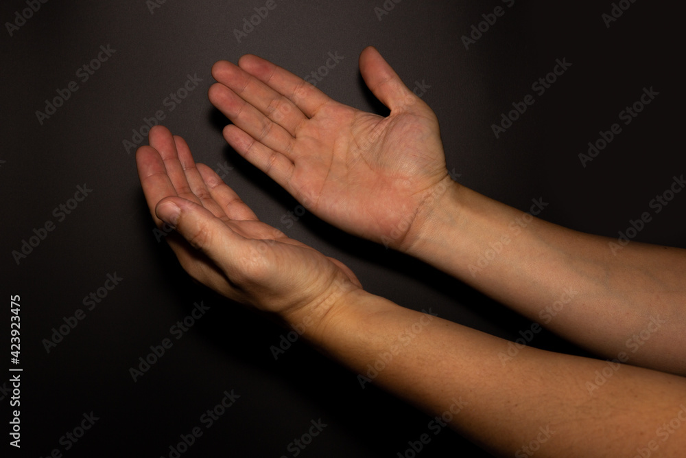 The man whose hand is praying on the dark background, selective focus. The man whose hand is praying on the dark background, selective focus.