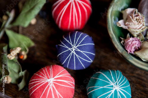  4 colorful balls on the table and dry roses on a plate