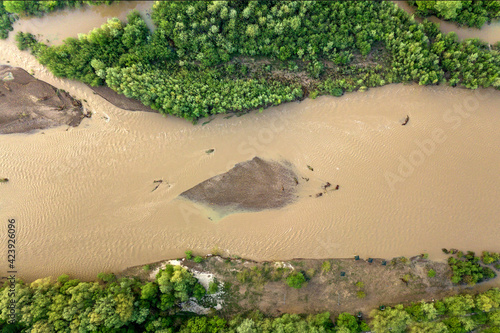 Aerial view of wide dirty river with muddy water in flooding period during heavy rains in spring.