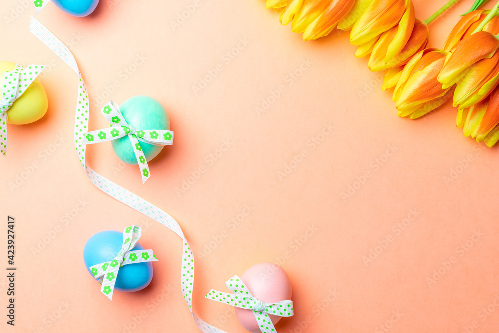 Easter banner. Colorful egg with tape ribbon, spring tulips, feathers on pastel pink background in Happy Easter decoration. Foil minimalist egg design, modern top view template.