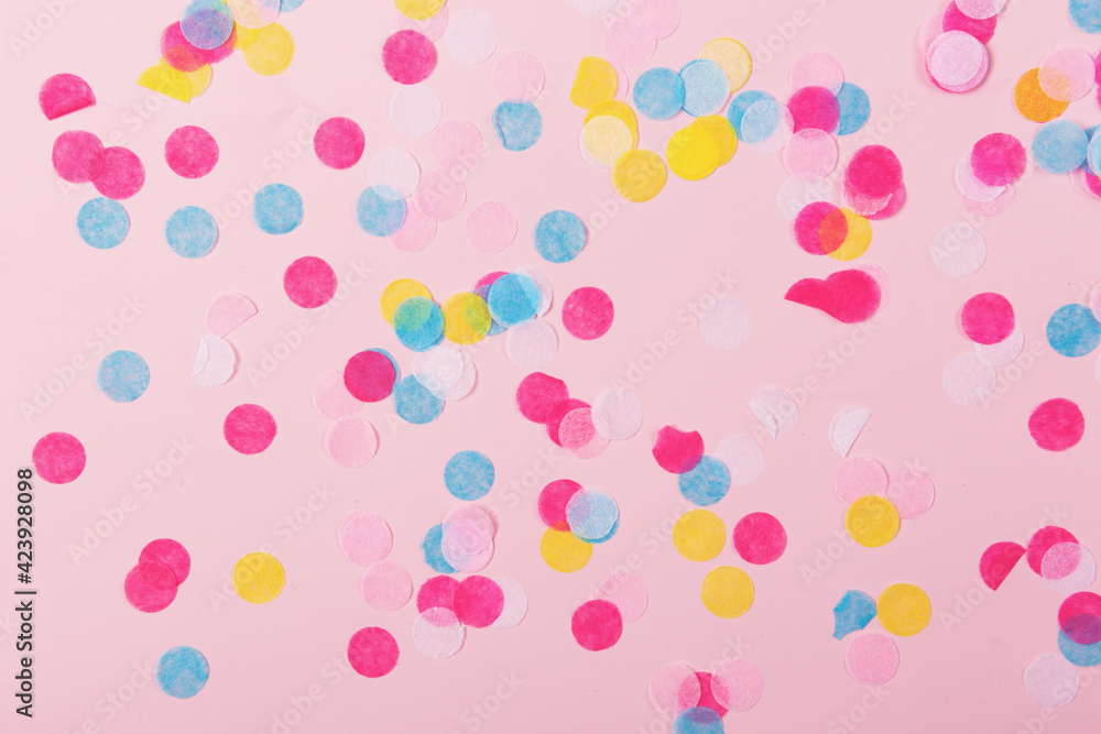 Falling colorful confetti on the pastel pink background. Flatlay, top view. 