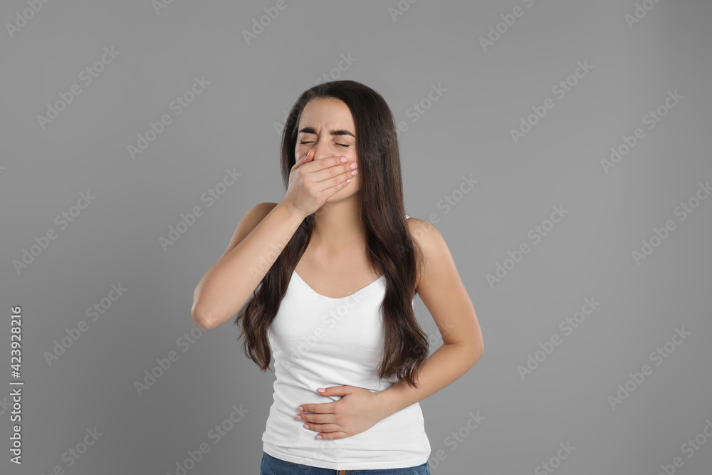 Young woman suffering from nausea on grey background. Food poisoning Young woman suffering from nausea on grey background. Food poisoning