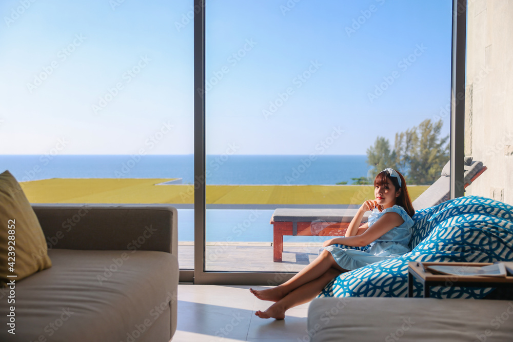 Portrait woman relaxing enjoying luxury lifestyle on blue soft sofa at home. Beautiful young lady Asian Caucasian female model, thinking looking happy up smiling cheerful of stress free weekend.