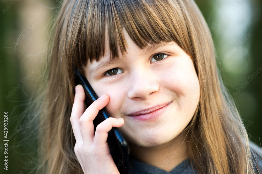 Portrait of pretty child girl with long hair talking on cell phone. Little female kid communicating using smartphone. Children communication concept. Portrait of pretty child girl with long hair talking on cell phone. Little female kid communicating using smartphone. Children communication concept.