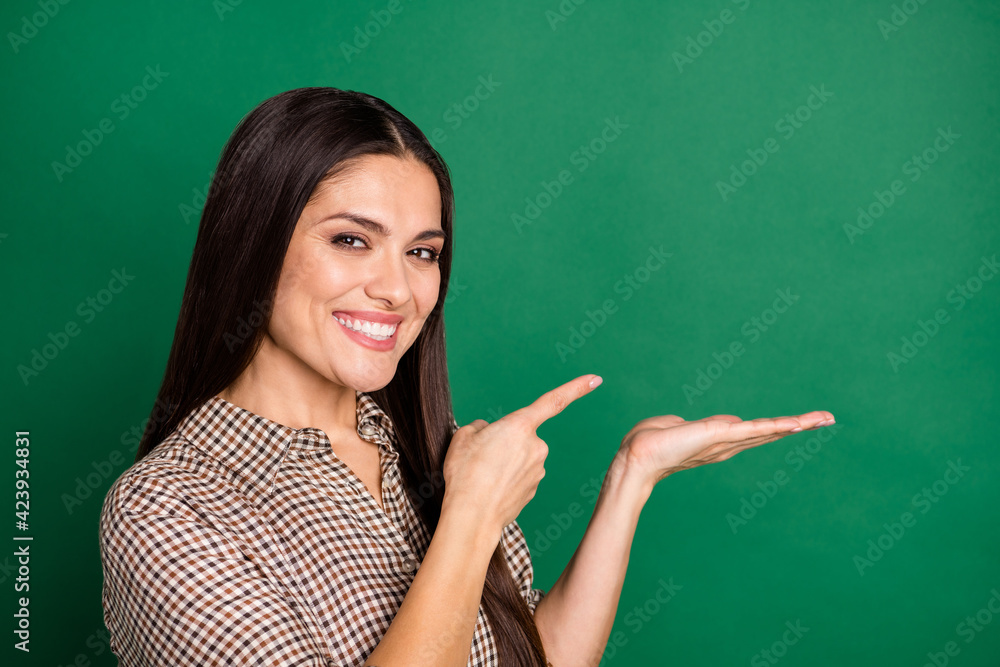 Photo of lady direct finger hold arm empty space wear checkered shirt isolated green color background Photo of lady direct finger hold arm empty space wear checkered shirt isolated green color background